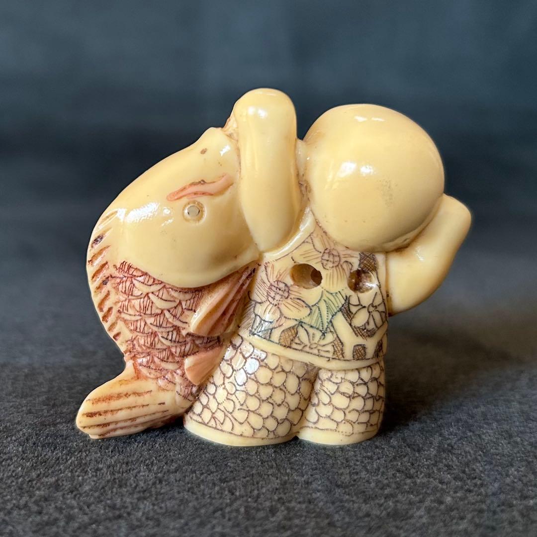 根付　魚を持つ子供の彫刻