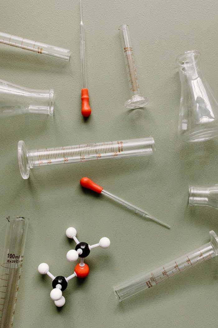 Scientific laboratory equipment with a molecular model on a green background.