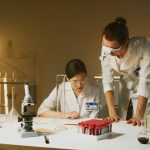 Two scientists working in a laboratory conducting experiments with various equipment and samples.